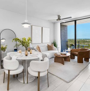 A modern living room with a dining table set for two.